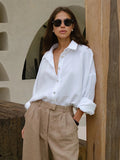 Relaxed Cotton Button-Down Shirt in White — front view on model, tucked into trousers