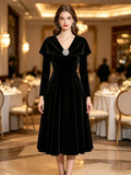 Velvet Midi Dress with Portrait Collar and Rhinestone Brooch in Black — front view on model