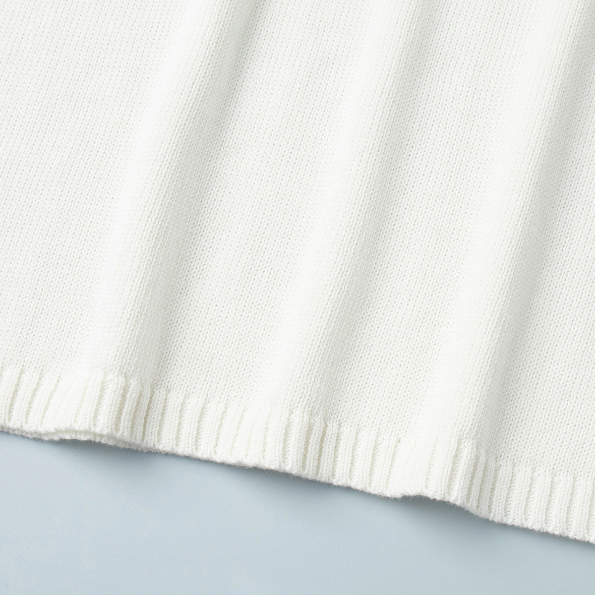 Oversized Open-Back Cotton Knit Sweater in Cream — close-up of the ribbed hem