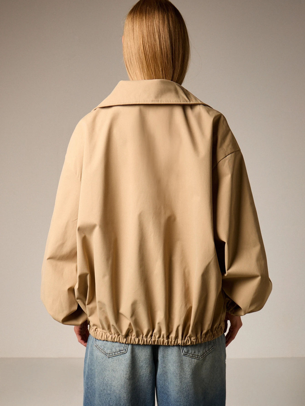 Oversized Half-Zip Funnel-Neck Windbreaker Jacket in Khaki — back view on model