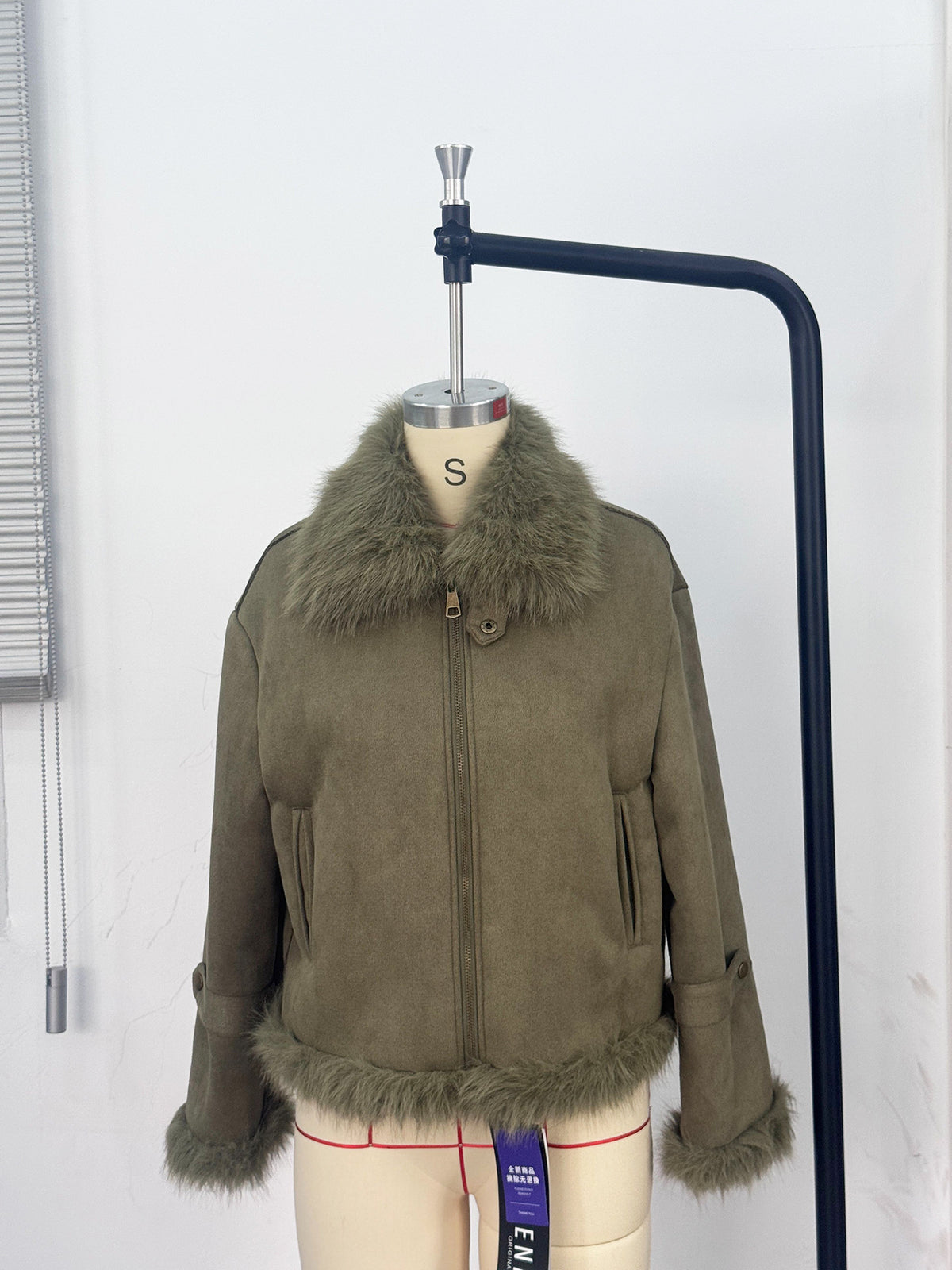 Cropped Faux Suede Shearling Jacket with Faux Fur Collar in Olive — front view on a dress form, zipped