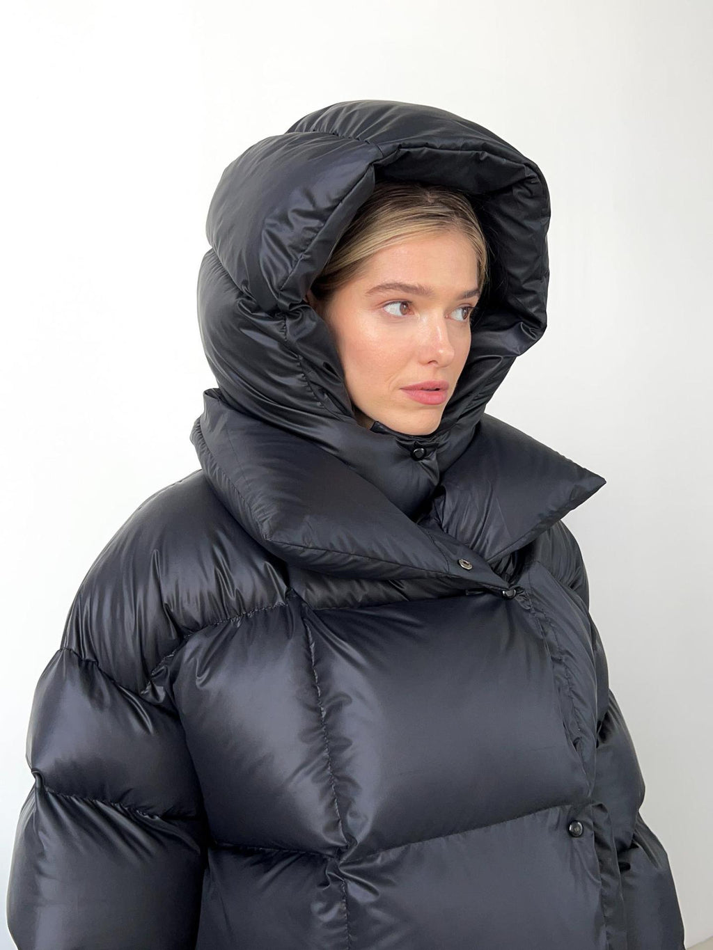 Cropped Hooded Puffer Jacket with Drawstring Hem in Black — hood up, close-up on model