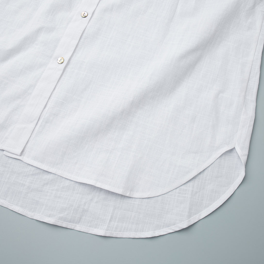 Relaxed Cotton Button-Down Shirt in White — close-up of the curved shirttail hem