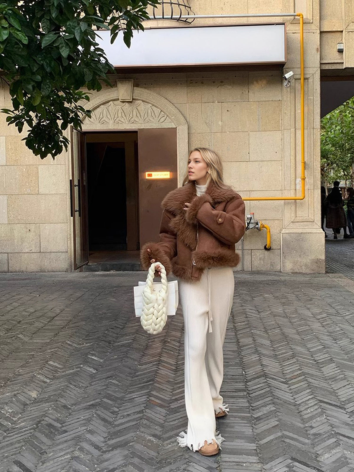 Cropped Faux Suede Shearling Jacket with Faux Fur Collar in Brown — full-length view on model with cream trousers