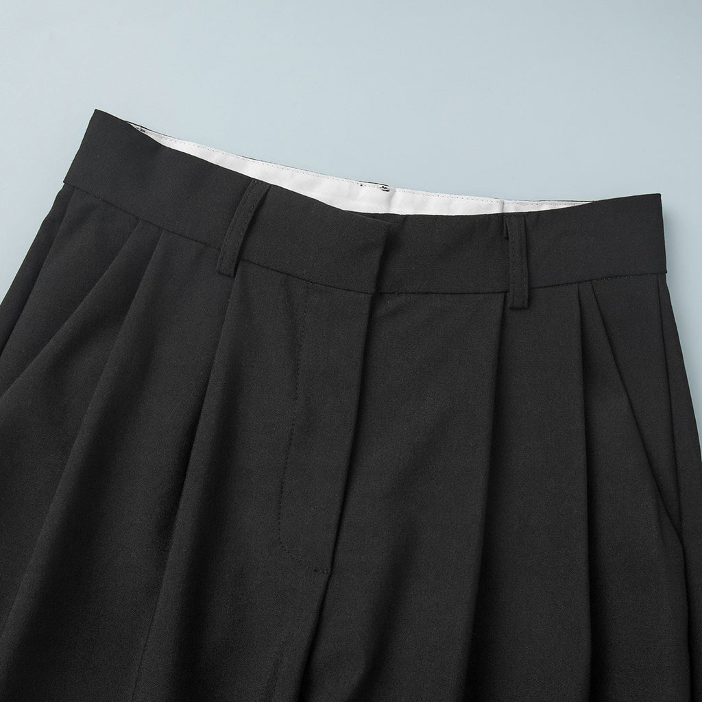 Pleated Wide-Leg Trousers in Black — close-up of waistband and pleats