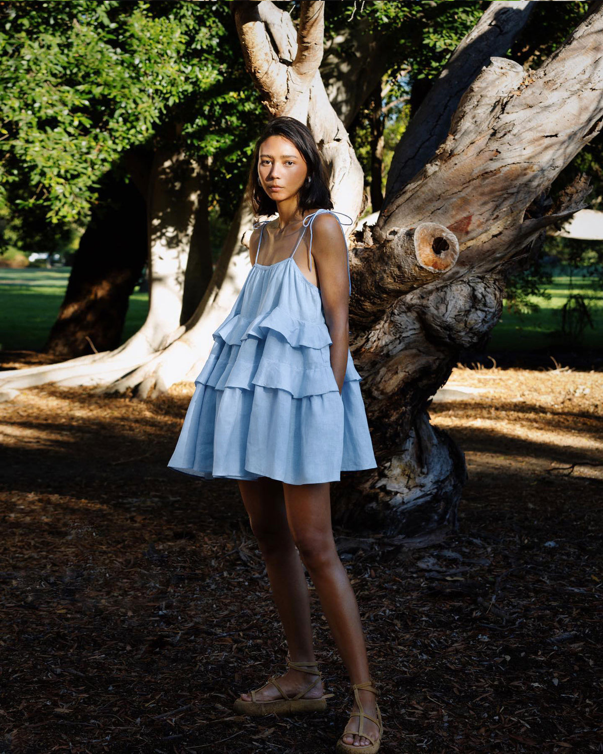 Tiered Ruffle Tie-Strap Mini Dress in Light Blue — on model under trees