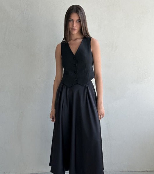 Satin A-Line Midi Skirt with Elastic Waist in Black — front view on model with a black vest